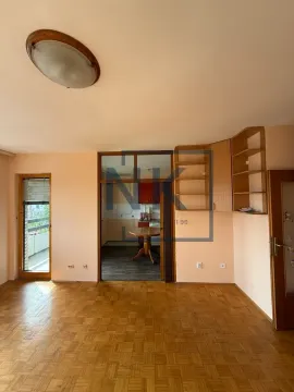 Empty living room with parquet flooring and a view of the kitchen. - image 3