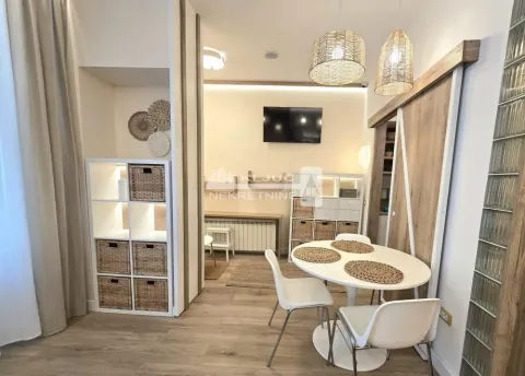 Living room with a dining table and shelving units with wicker baskets. - image 13
