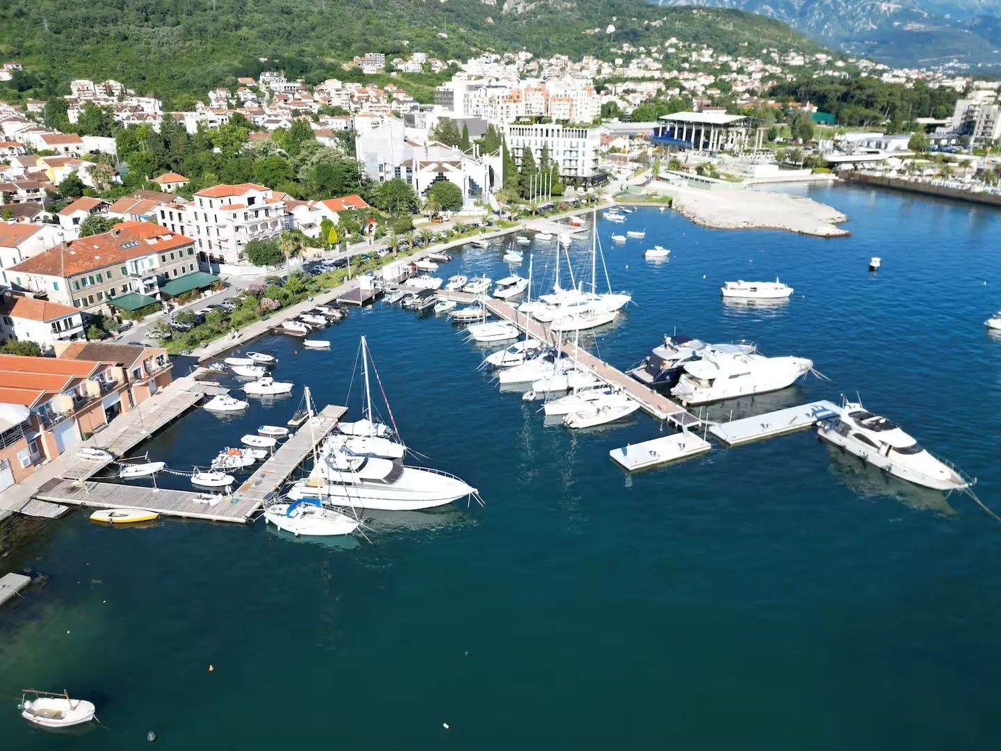 Pogled iz vazduha na marinu sa brodovima i obalu sa zgradama.