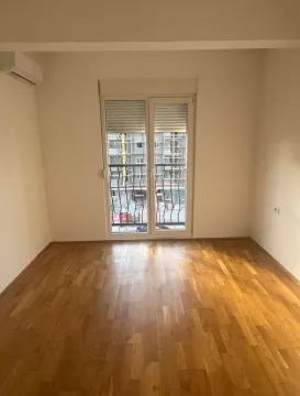 Empty room with parquet flooring and balcony doors. - image 6