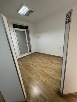 An empty room with laminate flooring, white walls, and a glass balcony door. - image 6