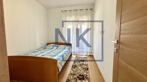 Manja spavaća soba sa drvenim krevetom i balkonskim vratima. - image 6