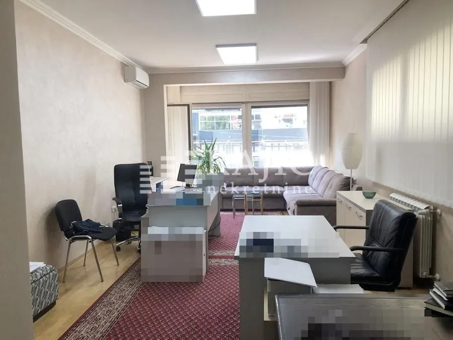 Spacious room set up as an office with a seating area.