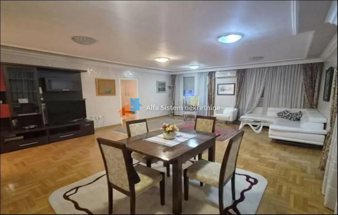Spacious living room with a dining area, sofa set, and television.
