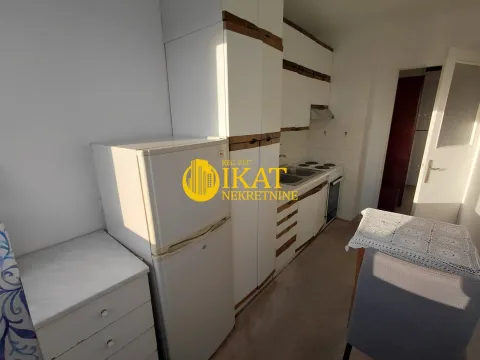 Small kitchen with white cabinetry, a refrigerator, and a dining table. - image 9