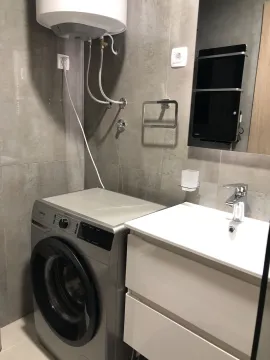 Modern bathroom with a washing machine and sink. - image 26