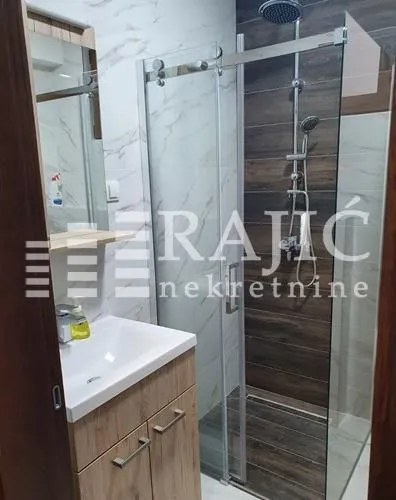 Modern bathroom with a shower cabin and a sink.