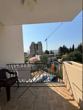 Nenamješten balkon sa sušilicom za veš i pogledom na naselje. - image 11