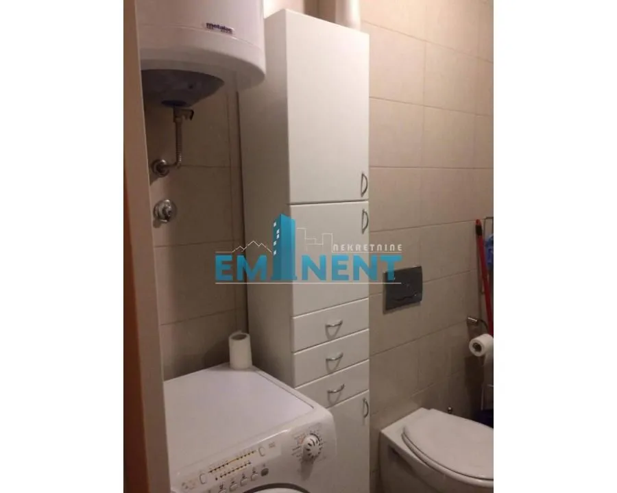 Bathroom equipped with sanitary ware, a washing machine, and a white cabinet.
