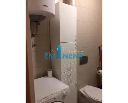 Bathroom equipped with sanitary ware, a washing machine, and a white cabinet. - image 11