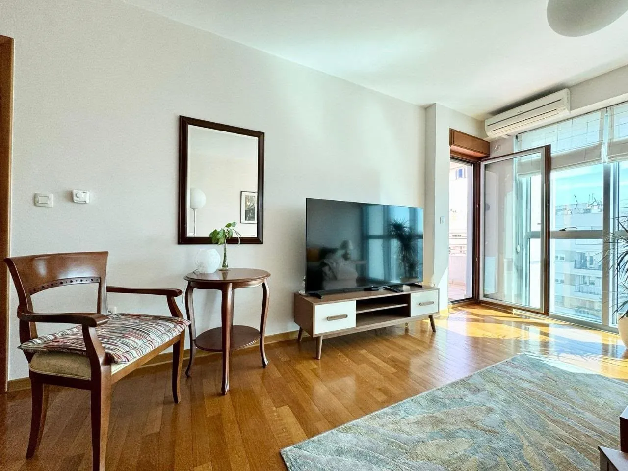 Living room with furniture, television, and access to the terrace.