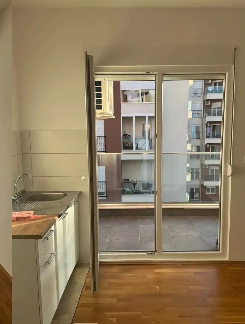 Small kitchen with a sink next to the balcony door.