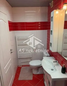Kupatilo sa tuš kabinom, umivaonikom i wc šoljom, obloženo crvenim i belim pločicama. - image 22