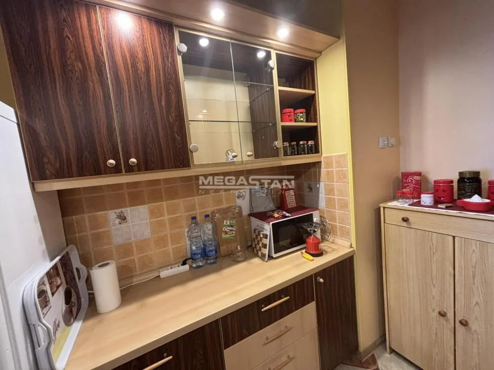 Kitchen with wooden cabinetry and wall tiles.