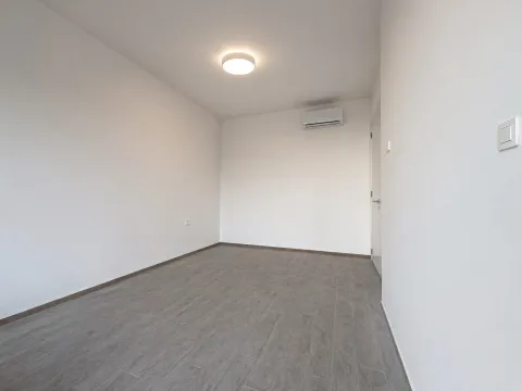 Prazna soba sa bijelim zidovima, sivim keramičkim pločicama i ugrađenim klima uređajem. - image 4