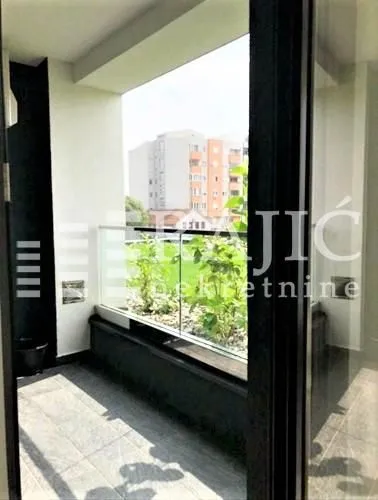 View of a spacious balcony with a glass railing.