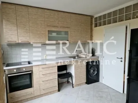 Kitchen with wooden cabinetry and built-in home appliances. - image 5