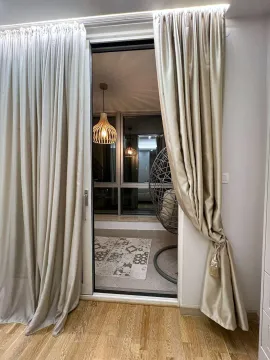 Pogled kroz balkonska vrata na natkrivenu terasu sa visećom foteljom i rasvjetom. - image 10
