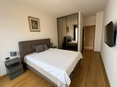 Uređena spavaća soba sa bračnim krevetom, plakarom sa ogledalom i TV-om. - image 5