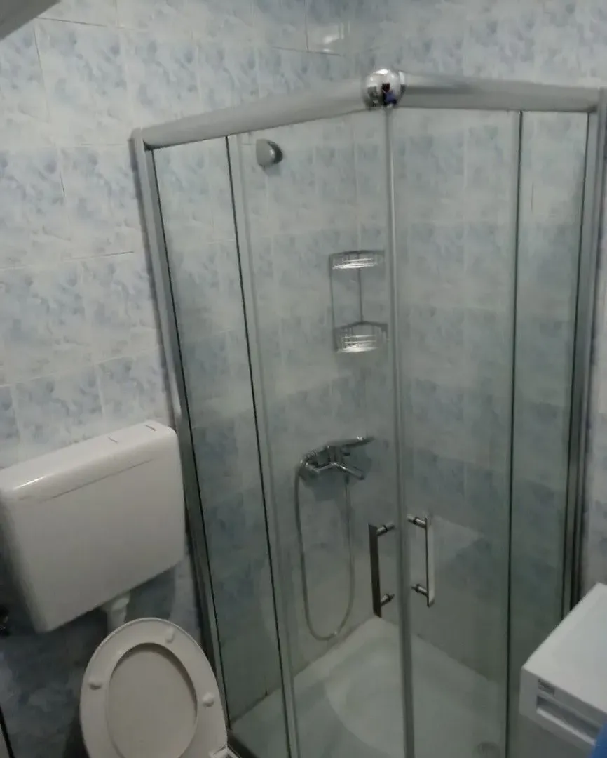 Small bathroom with a shower cabin and toilet.