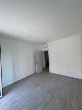 Prazna neopremljena soba sa bijelim zidovima i laminatom na podu. - image 4