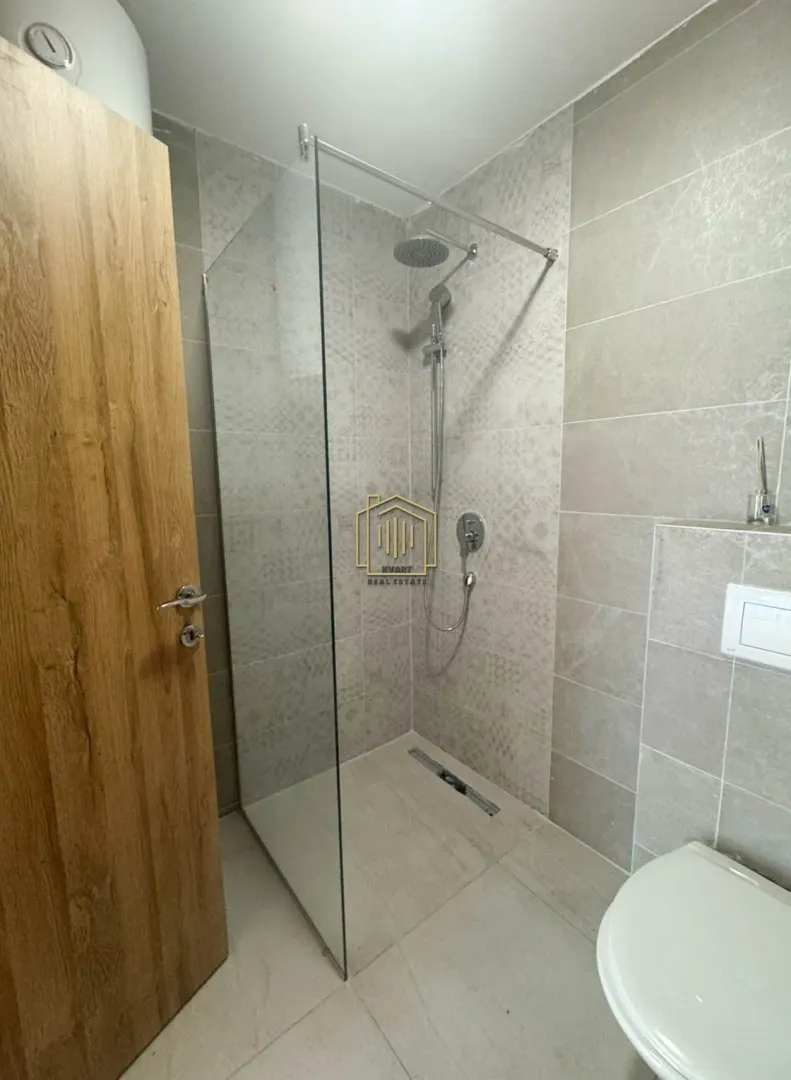 Moderne kupatilo sa tuš kabinom i ugradnom sanitarijom.