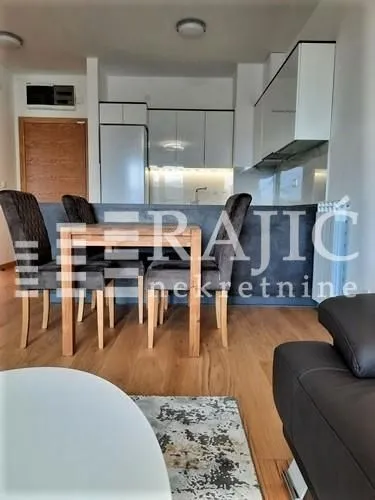 Living room with dining area and kitchen in the background.
