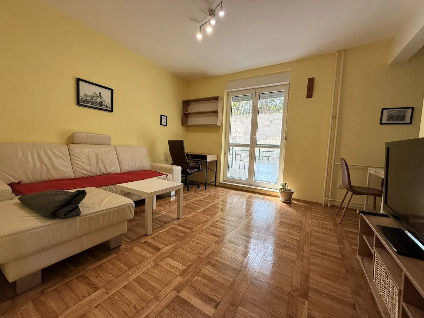 Living room with a sofa, TV, and access to the terrace.