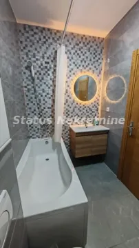 Moderno kupatilo sa kadom, umivaonikom i osvetljenim ogledalom. - image 6