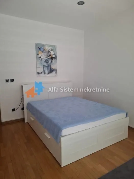 Bedroom with a double bed and a piece of art on the wall.