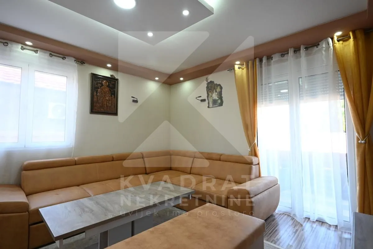 Living room with a sectional sofa and windows letting in plenty of natural light.