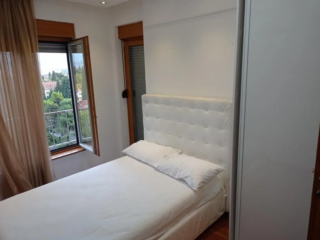 Bedroom with a double bed and a window overlooking greenery.