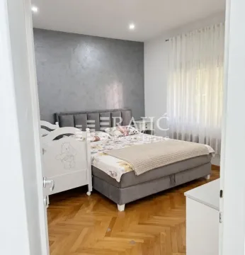 Furnished bedroom with a double bed and a cot. - image 7