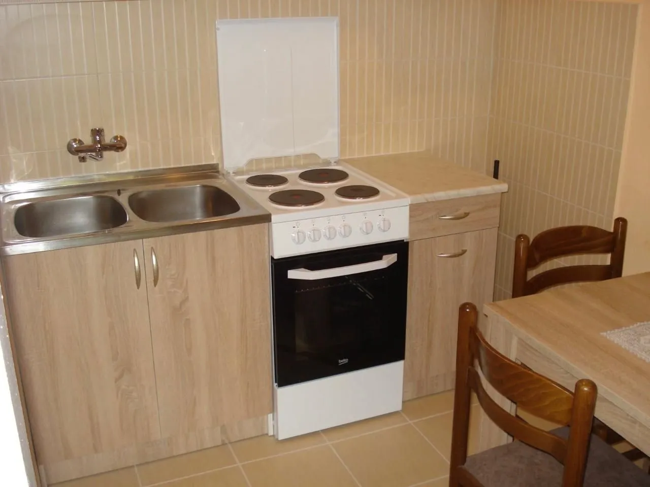 Small kitchen with a sink, stove, and dining table.