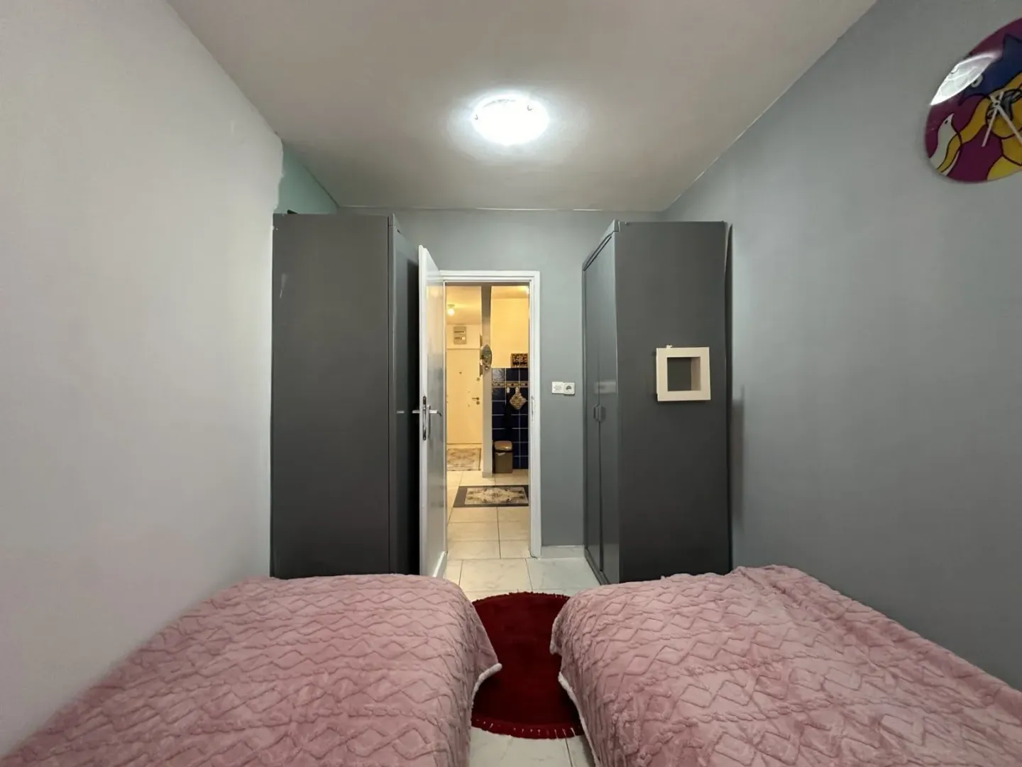 Bedroom with two beds and wardrobes.