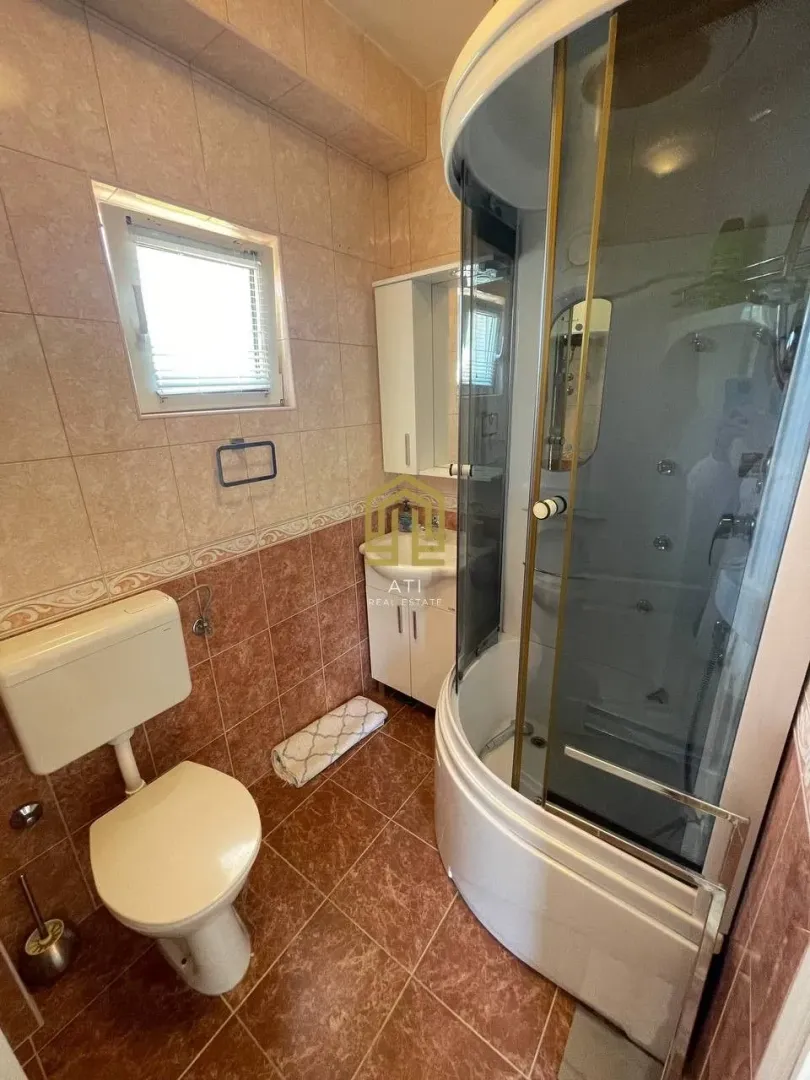 Manje kupatilo sa tuš kabinom, WC šoljom i umivaonikom.