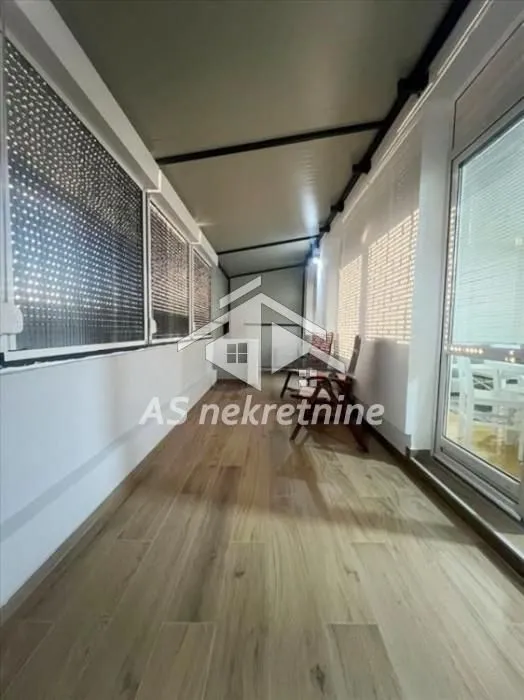Enclosed terrace with wooden flooring and a view.