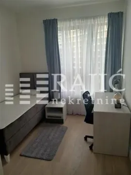 Nameštena spavaća soba sa krevetom, radnim stolom i prozorom. - image 6
