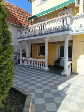 Pogled na terasu i ulazni deo kuće sa stubovima. - image 8