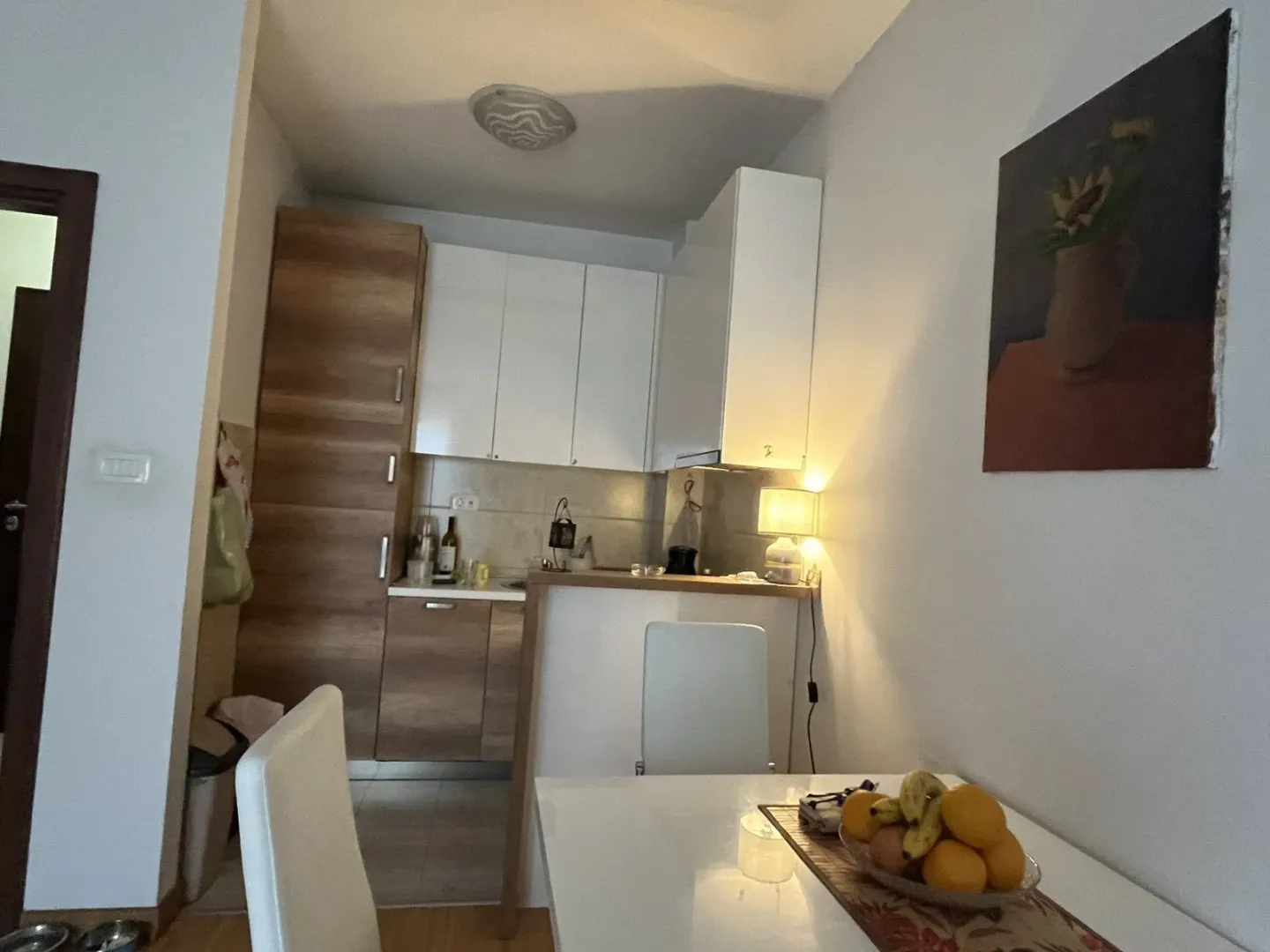 Mala, moderna kuhinja sa trpezarijskim stolom i stolicama.