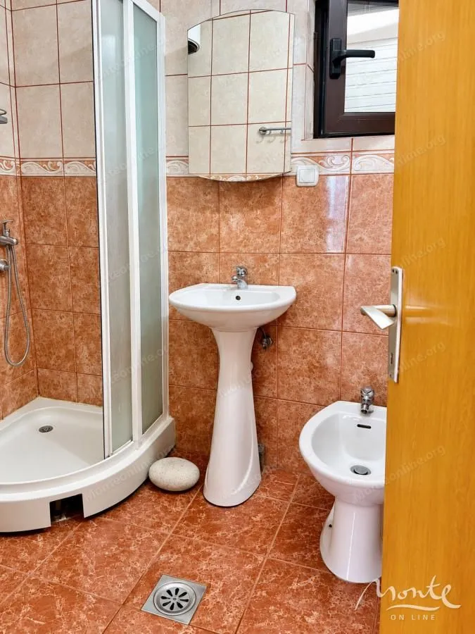 Kupatilo sa tuš kabinom, umivaonikom, bideom i ogledalom.