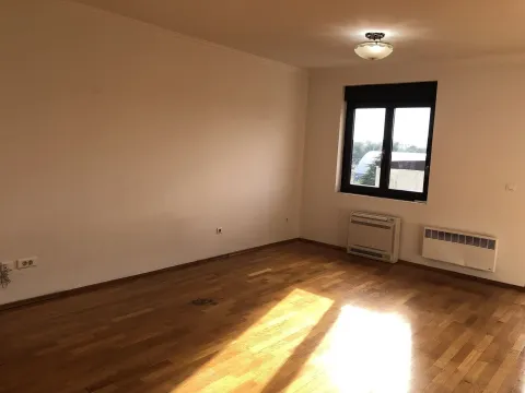 An empty room with parquet flooring and sunlight coming through a window. - image 6