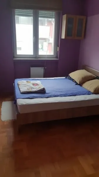 Bedroom with a bed, window, and wall-mounted cabinet.