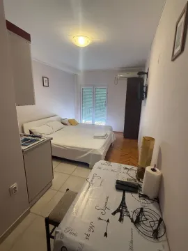 Manja spavaća soba sa bračnim krevetom, kuhinjskim elementima i trpezarijskim stolom. - image 2