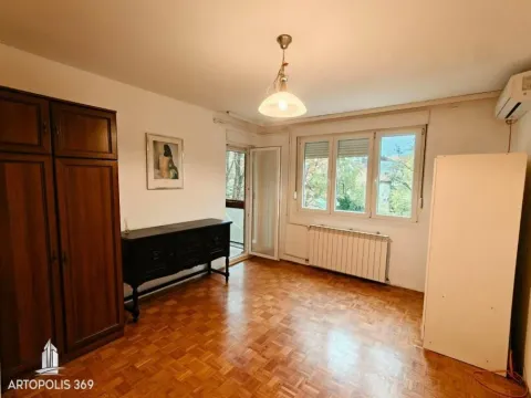 Nameštena spavaća soba sa drvenim ormarom, parketom i izlazom na terasu. - image 14