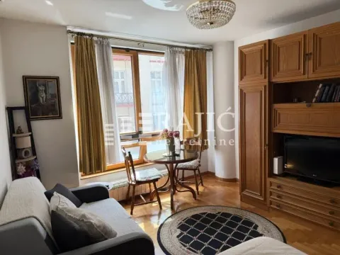 Living room with a sofa, dining table, and wooden closets. - image 7