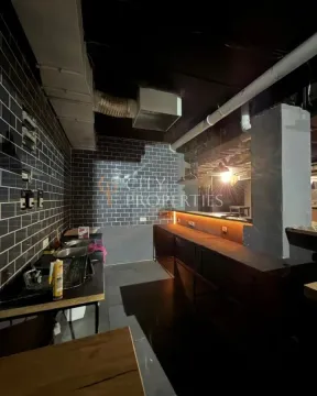 Kitchen space with dark ceramic tiles and a counter under furnishing. - image 5