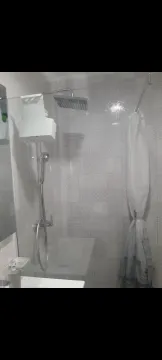 A section of a bathroom showing a shower with decorative grey tiles. - image 13