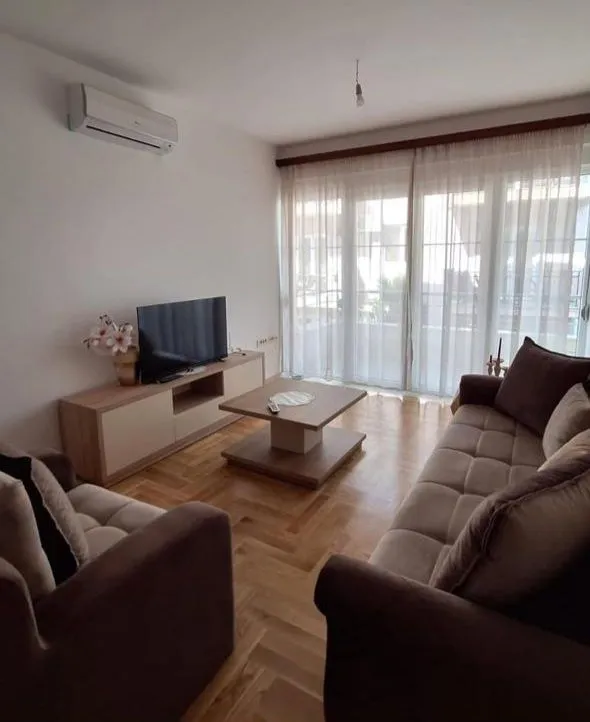 Living room with sofa set, TV unit, and access to the terrace.
