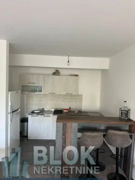Small kitchen with cabinets and a breakfast bar with bar stools. - image 6